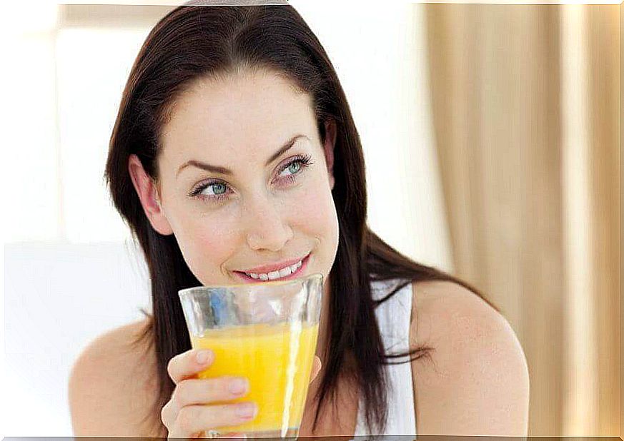 smiling woman with glass of pineapple water