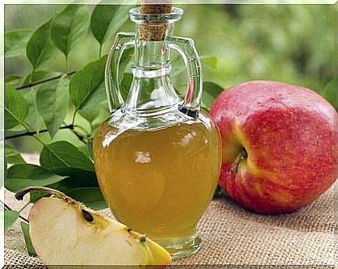 Apple and bottle of apple cider vinegar